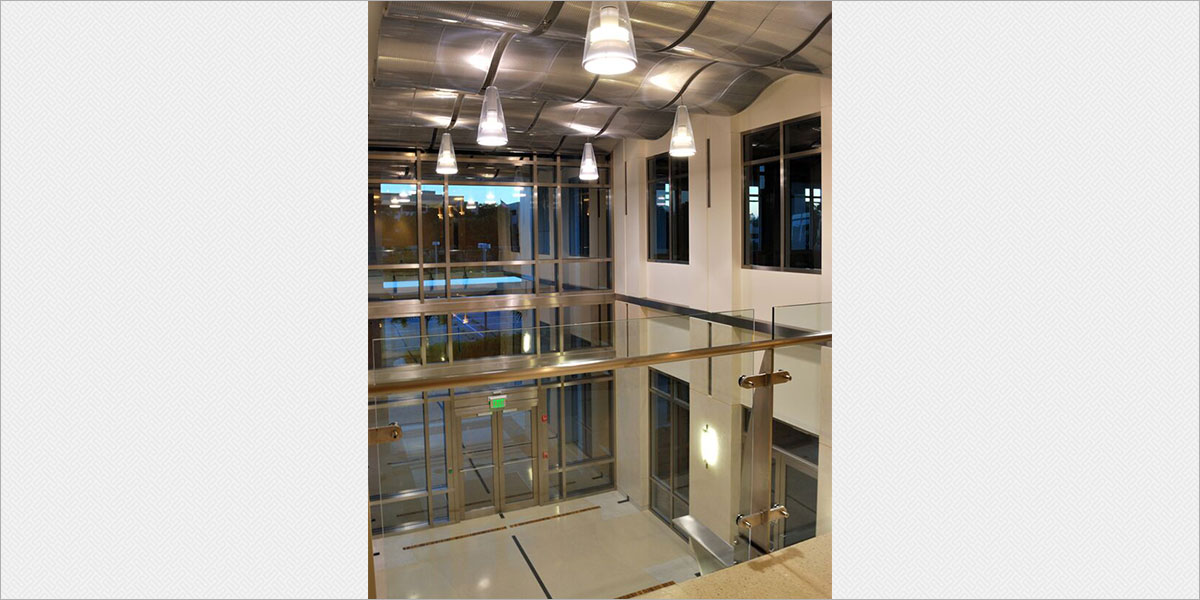 Louis Poulsen Charisma King metal halide pendants are suspended through the undulating metal ceiling in the two-story main lobby.