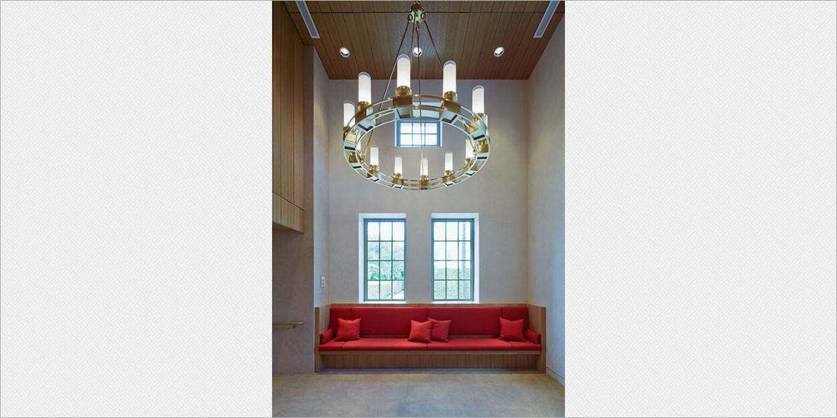 Custom 60-in diameter brass chandeliers by Crenshaw Lighting in the theatre lobby.